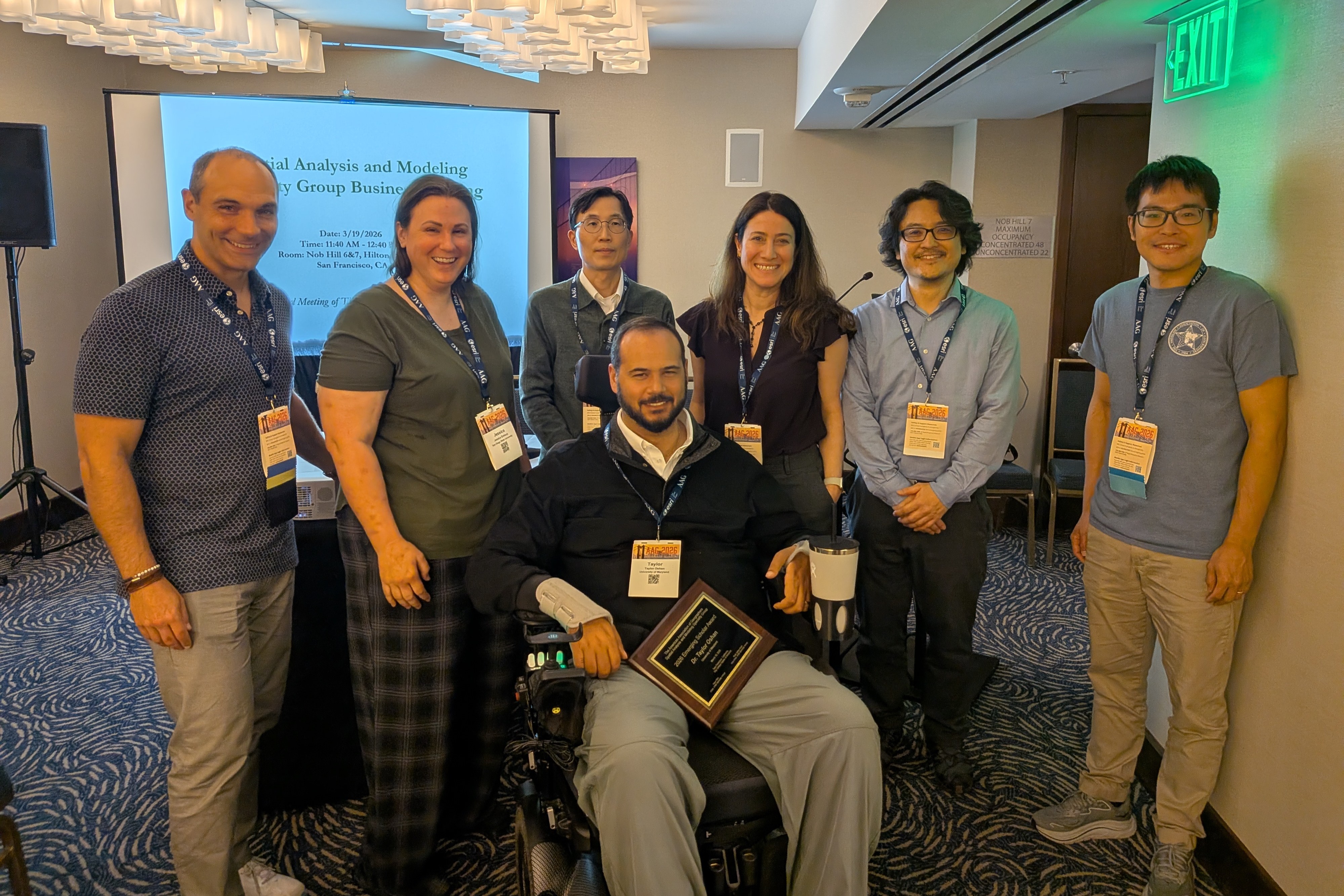 An image of SAM Board Members from left to right: Peter Kedron, Jessica Embury, Hyun Kim, Taylor Oshan, Seda Şalap-Ayça, Atsushi Nara, & Ziqi Li.